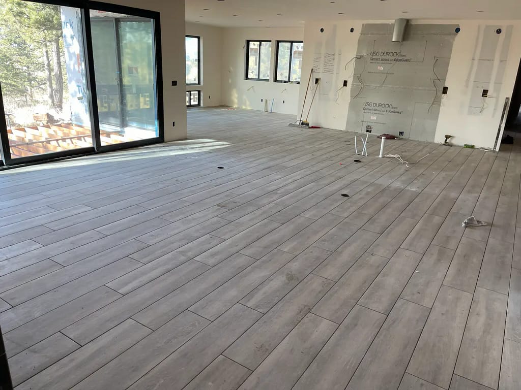 Wood-look residential floor tile installed in Parker, CO, in a large, open-concept living space by XCEL TILE.