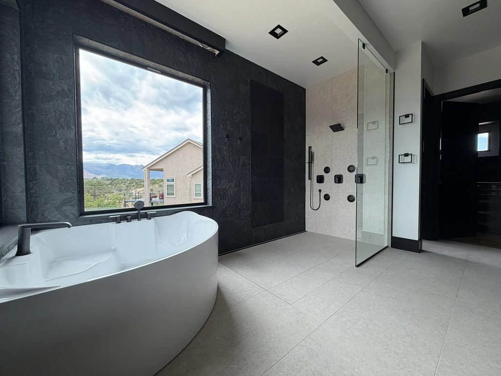 Master-level tile craftsmanship featuring a custom glass shower and dark slate by XCEL TILE in Castle Rock, CO.